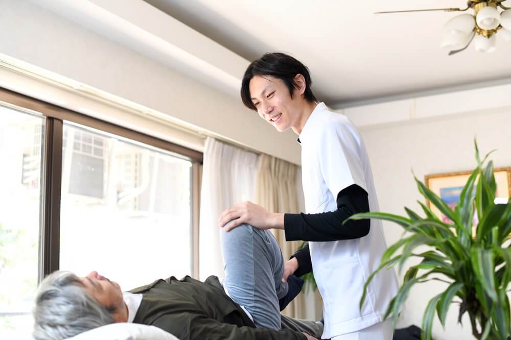 自宅でリハビリを行う高齢者と作業療法士