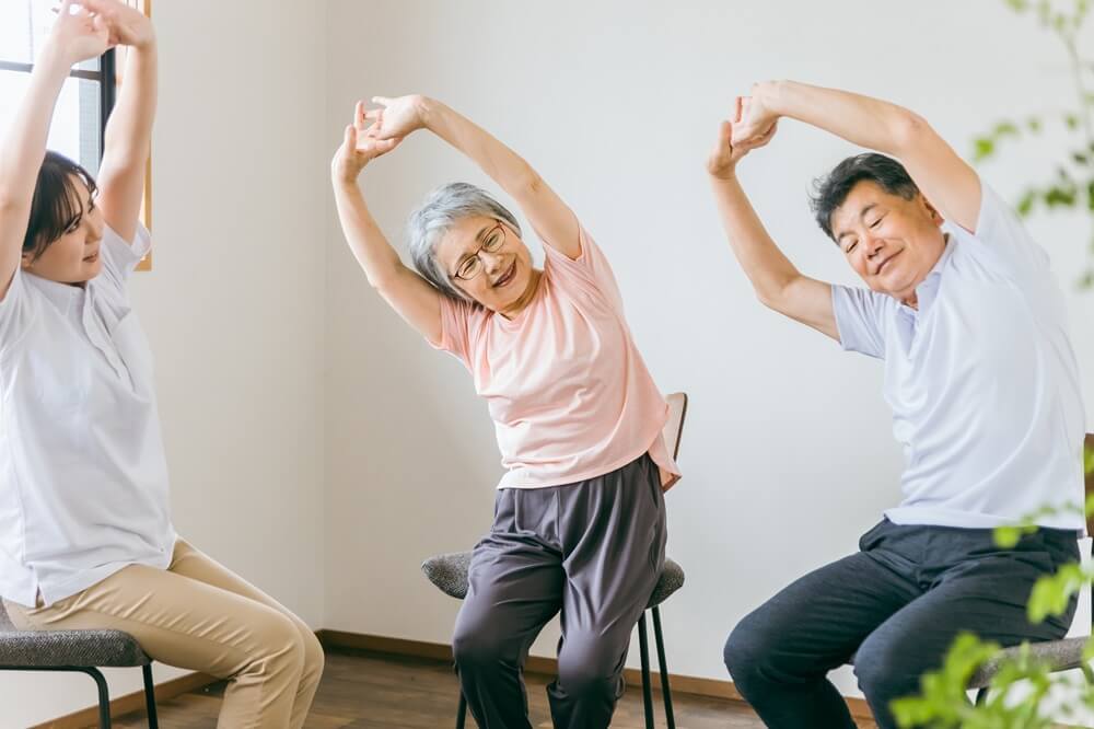 デイサービスでの集団体操に参加する高齢者たち