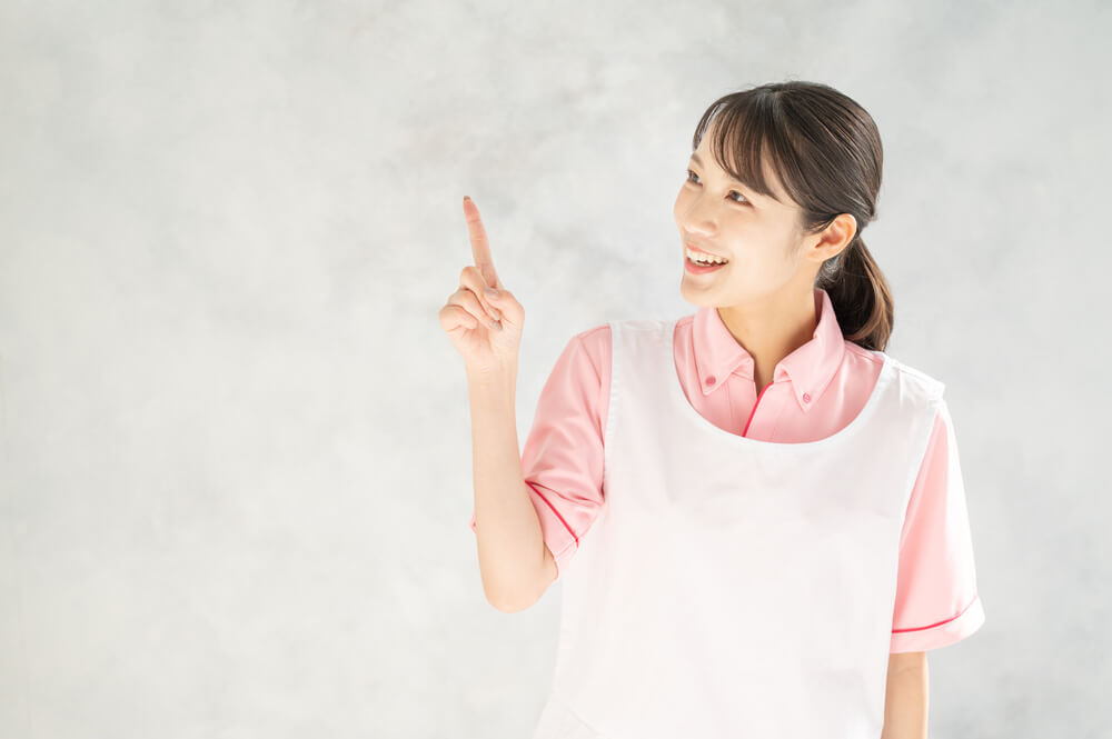 笑顔で指をさしながら説明する介護士の女性
