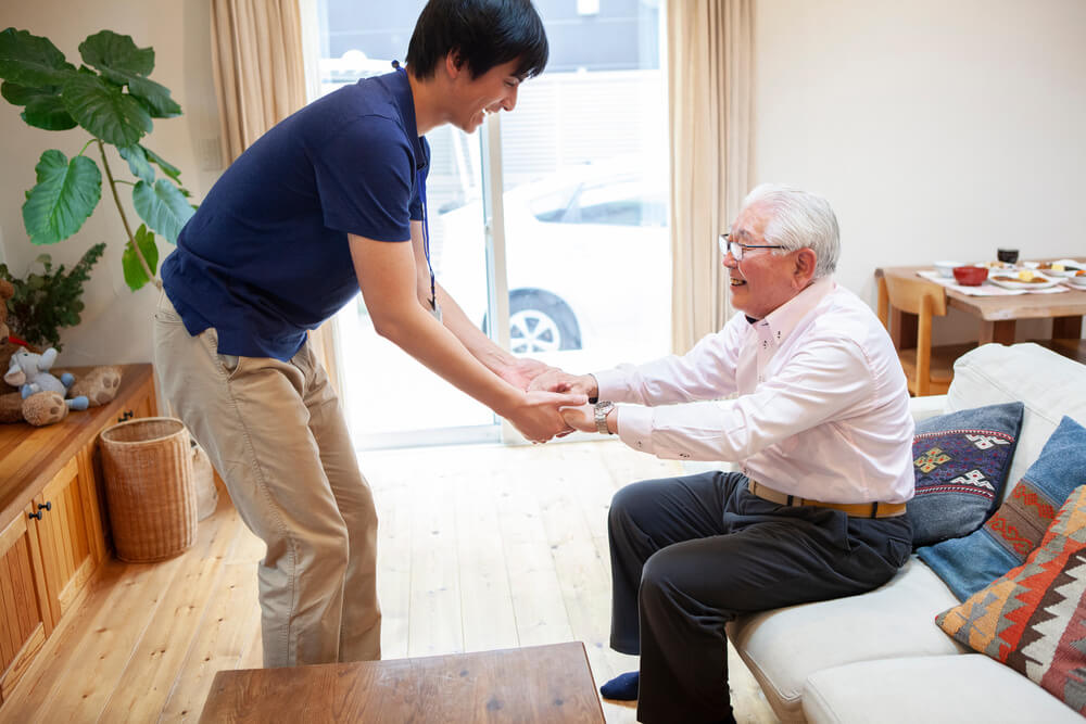 介護士が立位の補助をしている様子